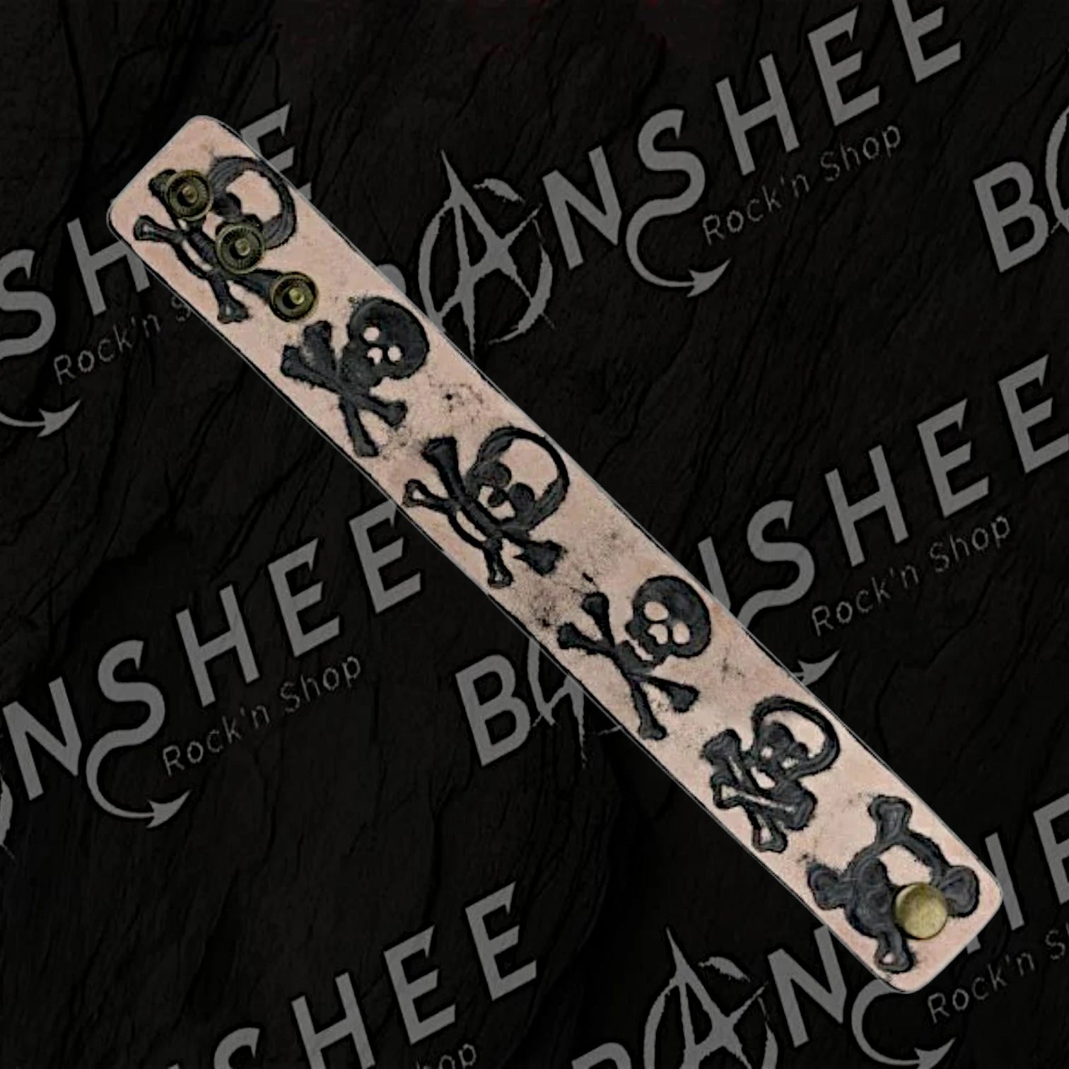 Bracelet en cuir avec têtes de mort et os croisés en relief