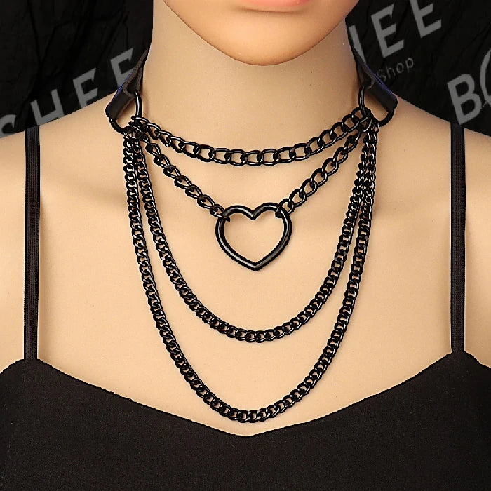 Ras de cou gothique noir porté avec chaînes et pendentif cœur métallique